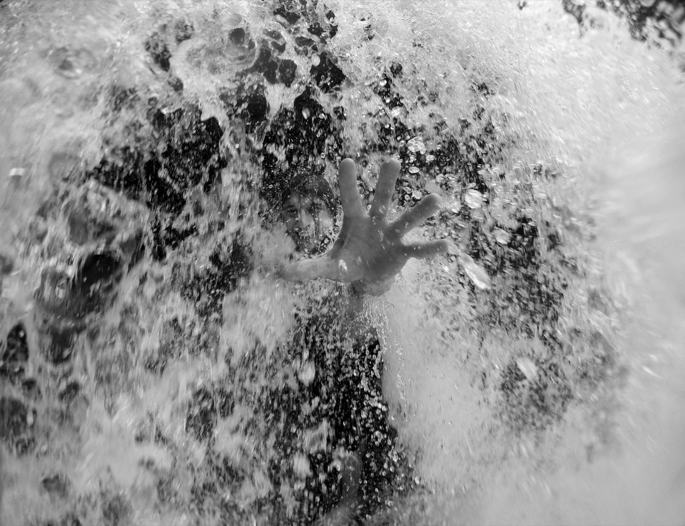 A hand reaching up through the water